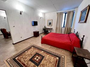 a bedroom with a red bed and a television at Хотел Антик in Pernik