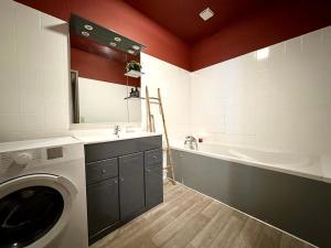 a bathroom with a washing machine and a bath tub at LE COSY - Plain-Pied in Mont-de-Marsan