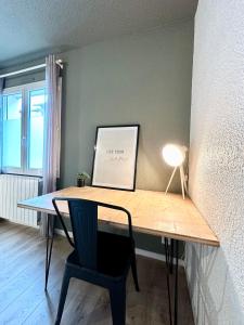 a desk in a room with a chair and a picture at LE COSY - Plain-Pied in Mont-de-Marsan