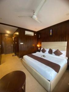 1 dormitorio con 1 cama grande y 1 mesa en Hotel Royale Hills en Rishīkesh