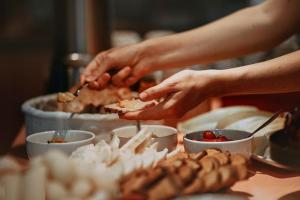 a person is holding a piece of food on a table at PFA Hotel Viareggio in Viareggio