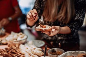 a woman is holding a piece of bread with a spoon at PFA Hotel Viareggio in Viareggio