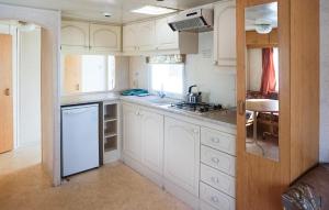 a kitchen with white cabinets and a sink at 2 Bedroom Lovely Home In Mielno in Mielno