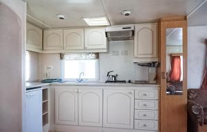 a kitchen with white cabinets and a sink at 2 Bedroom Lovely Home In Mielno in Mielno