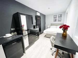 a black and white bedroom with a bed and a desk at Letzi Private En-Suite In Harrow in Pinner