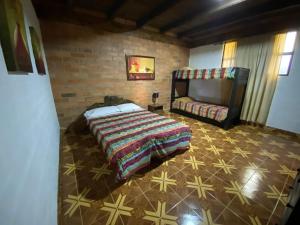 a bedroom with a bed and a brick wall at Finca Hotel Paraiso Urrao in Urrao