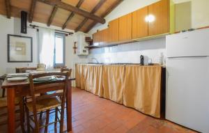 uma cozinha com uma mesa e um frigorífico branco em 2 Bedroom Cozy Home In Paciano em Paciano