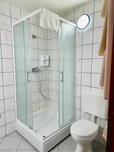 uma casa de banho com um chuveiro e um WC. em Dubrovnik Apartments em Dubrovnik