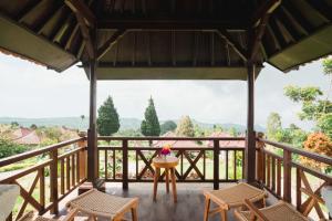 een uitzicht vanaf het terras van een huis met stoelen en een tafel bij Girihill Farmhouse in Munduk