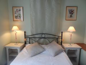 - une chambre avec un lit et 2 lampes sur les tables dans l'établissement Le Pelerine, à Sauveterre