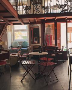 Un comedor con mesas y sillas y ventanas. en Alface Hall Hostel & Bar, en Lisboa