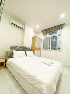 duże białe łóżko w pokoju z oknem w obiekcie Aloha House Apartment w Ho Chi Minh