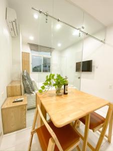 a dining room with a wooden table and a couch at Aloha House Apartment in Ho Chi Minh City