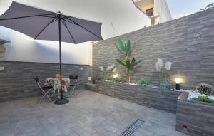 un patio con una mesa y una sombrilla en Stunning Home In Catania With Sauna, en Catania