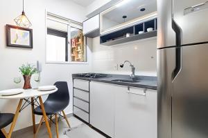 a kitchen with a stainless steel refrigerator and a small table at Exclusivo na Liberdade com Piscina e Wi-fi 300mb in Sao Paulo