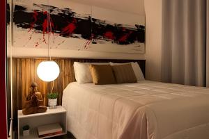 聖保羅的住宿－Exclusivo na Liberdade com Piscina e Wi-fi 300mb，卧室配有白色的床和绘画作品