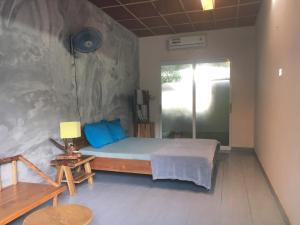 1 dormitorio con 1 cama con almohadas azules en Confetti House en Quy Nhon