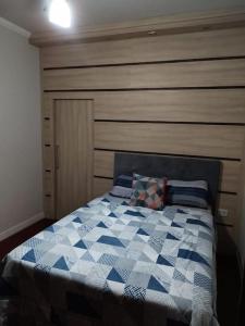 a bedroom with a bed with a blue and white quilt at Residencia Cidade Verde 1 Ourinhos in Ourinhos