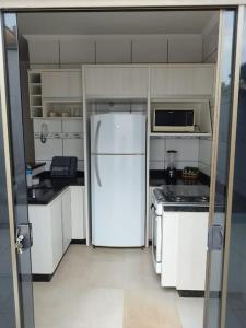 a white kitchen with a refrigerator and a stove at Residencia Cidade Verde 1 Ourinhos in Ourinhos