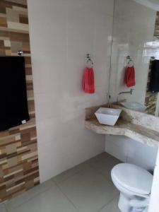 a bathroom with a white toilet and a sink at Residencia Cidade Verde 1 Ourinhos in Ourinhos