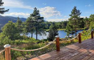 a wooden deck with a rope fence and a lake at 4 Bedroom Awesome Home In Mykland in Mykland