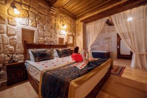 a bedroom with a bed in a room with stone walls at Mithra Cave Hotel in Goreme