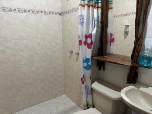 a bathroom with a shower curtain with flowers on it at Finca Hotel Paraiso Urrao in Urrao