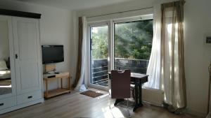 a room with a window and a desk and a television at Zimmer mit Aussicht in Schulenberg im Oberharz