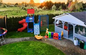 a childrens playground with a play set on the grass at Lovely Home In Chlopy With Kitchen in Chłopy