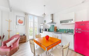 Una cocina con una mesa y un refrigerador rojo. en Nice Home In Royan With Wifi, en Royan 30 fotos más