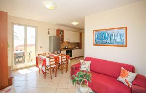 een woonkamer met een rode bank en een tafel bij Amazing Apartment In Marzamemi With House A Panoramic View in Marzamemi