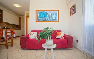 a living room with a red couch and a table at Pet Friendly Apartment In Marzamemi in Marzamemi +9 photos