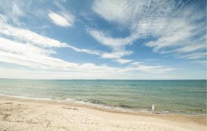 a beach with the ocean and a cloudy sky at Pet Friendly Apartment In Marzamemi in Marzamemi