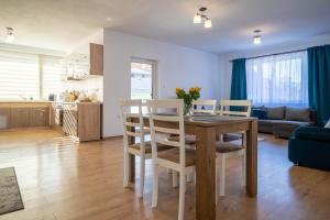 a kitchen and living room with a table and chairs at Lotus Apartman I in Odorheiu Secuiesc
