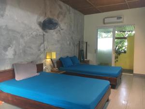 1 dormitorio con 2 camas y pared de piedra en Confetti House en Quy Nhon