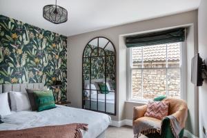 um quarto com uma cama, uma cadeira e uma janela em The Prince of Waterloo - Boutique Guest Rooms em Winford