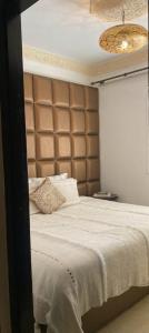 a bedroom with a large bed with a brown headboard at Luxury appartment Oumi in Martil