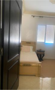 ein kleines Schlafzimmer mit einem Bett und einem Fenster in der Unterkunft Luxury appartment Oumi in Martil