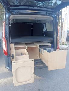 uma mala aberta de um carro com caixas dentro em Ford Transit Custom Camper em Palma de Maiorca
