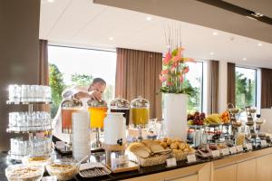 - un buffet de plats et de boissons sur une table dans l'établissement Mercure Gdynia Centrum, à Gdynia