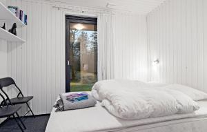 a white bedroom with a bed and a chair at Lovely Home In Bording With Wifi in Bording Stationsby