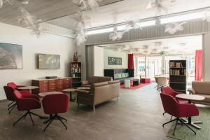 a waiting room with chairs and tables and a tv at Centro Magliaso in Magliaso