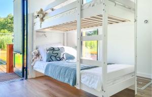 białe łóżko piętrowe w pokoju z oknem w obiekcie Cozy Ship In Mielno With Kitchen w mieście Mielno