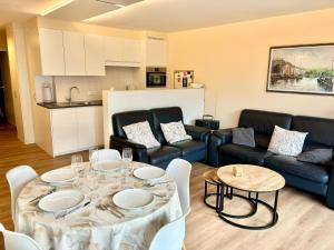 een woonkamer met een tafel en een bank bij Peppino 0101 in Koksijde +8 foto's