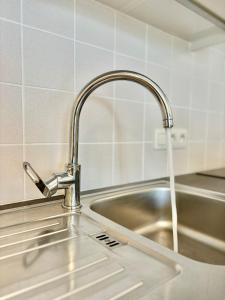 een gootsteen met water uit een kraan bij Peppino 0101 in Koksijde