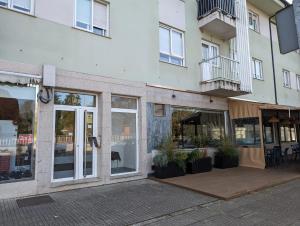 a store front with glass doors and potted plants at Don Manuel Cuntis in Cuntis