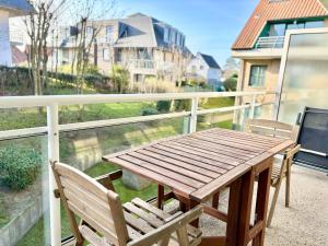 een houten tafel en 2 stoelen op een balkon bij Peppino 0101 in Koksijde