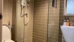 ein Bad mit einer Dusche und einem WC in der Unterkunft Malina Cozy Suite 3.0 @Kozi Square in Kuching