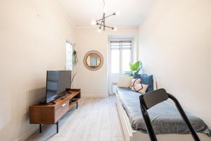 een woonkamer met een bank en een tv bij Le GRAND JEAN in Nice
