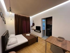 a bedroom with a bed and a table and a dining room at Apartments Sadiku with swimming pool & jacuzzi in Sarandë